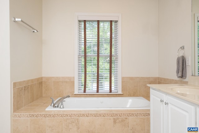 bathroom featuring a healthy amount of sunlight, vanity, and a bath