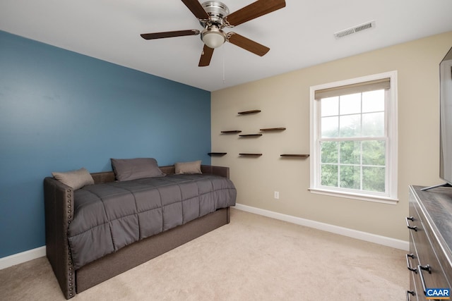 bedroom with baseboards, a ceiling fan, visible vents, and light colored carpet