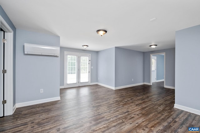 empty room featuring dark wood-style floors, a wall mounted AC, and baseboards