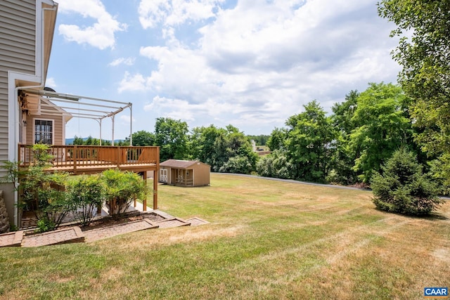 view of yard with a deck, a shed, an outbuilding, and a pergola