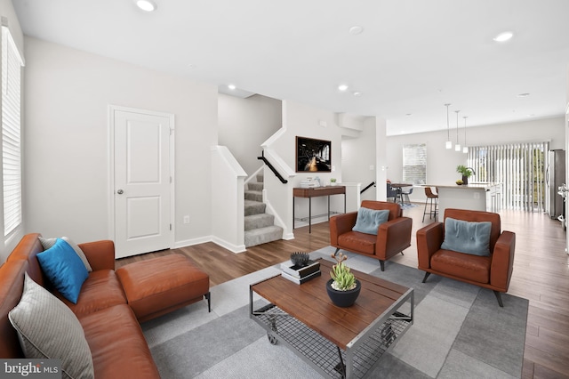 living room with light wood-style flooring, stairs, baseboards, and recessed lighting