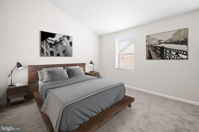 carpeted bedroom featuring baseboards and vaulted ceiling