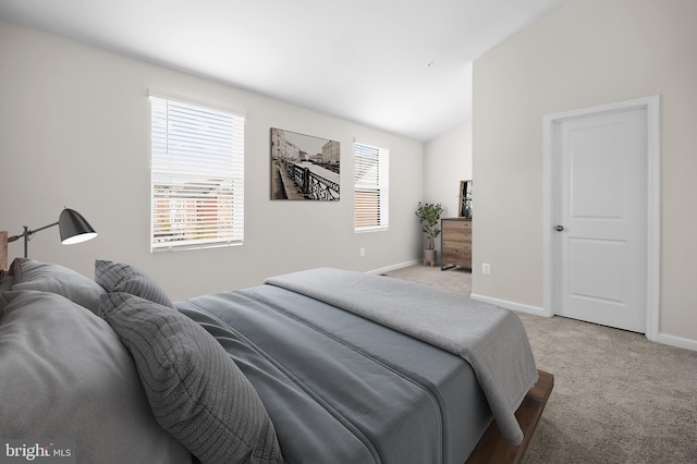 bedroom featuring lofted ceiling, baseboards, and light colored carpet