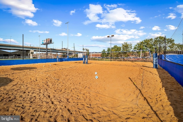 view of home's community featuring fence and volleyball court