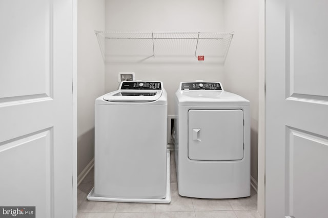 laundry room featuring laundry area, washing machine and clothes dryer, and light tile patterned floors