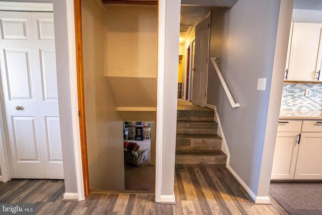 staircase with baseboards and wood finished floors