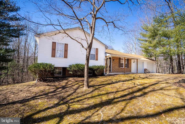 split level home featuring a garage and brick siding