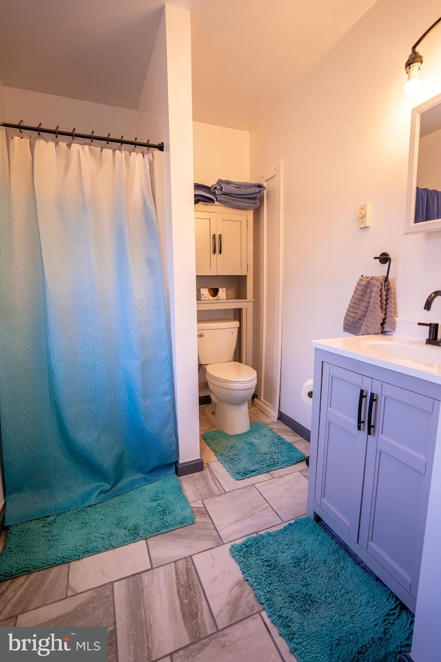 bathroom with baseboards, vanity, toilet, and a shower with curtain