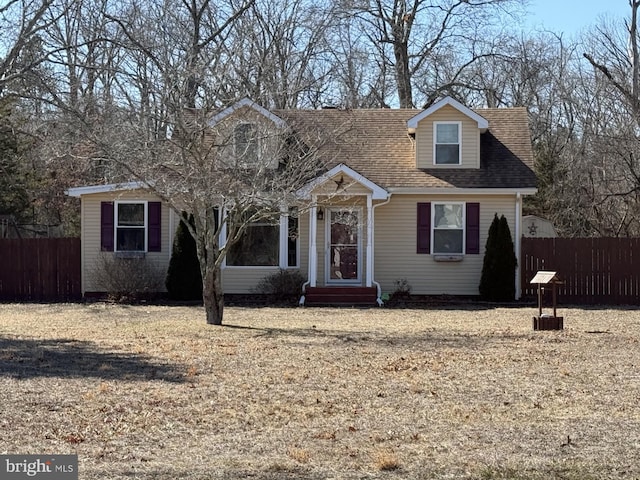 cape cod home with fence and roof with shingles