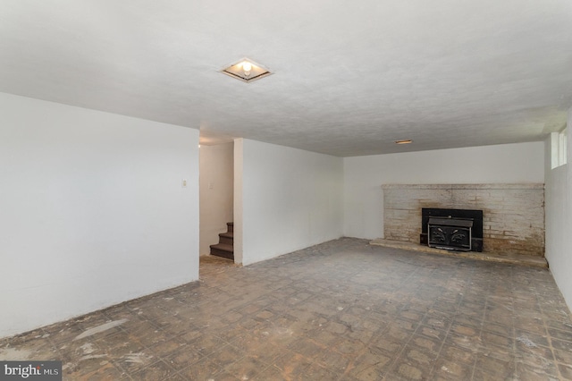 unfurnished living room featuring stairway and tile patterned floors