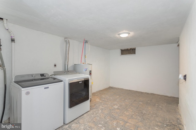 laundry room with laundry area, water heater, and separate washer and dryer