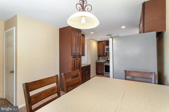 kitchen with pendant lighting, recessed lighting, backsplash, appliances with stainless steel finishes, and baseboards