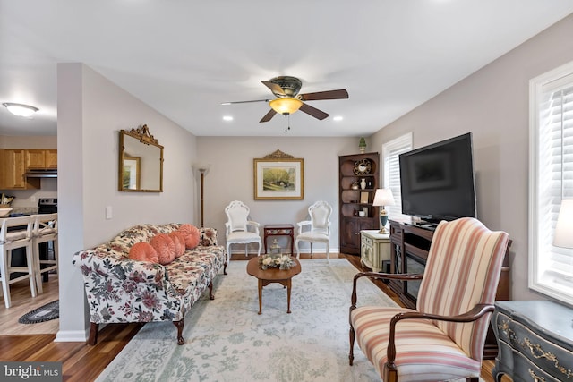 living area featuring recessed lighting, ceiling fan, baseboards, and wood finished floors