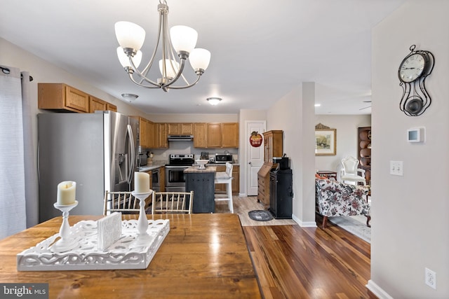 dining space with dark wood-type flooring, a chandelier, and baseboards