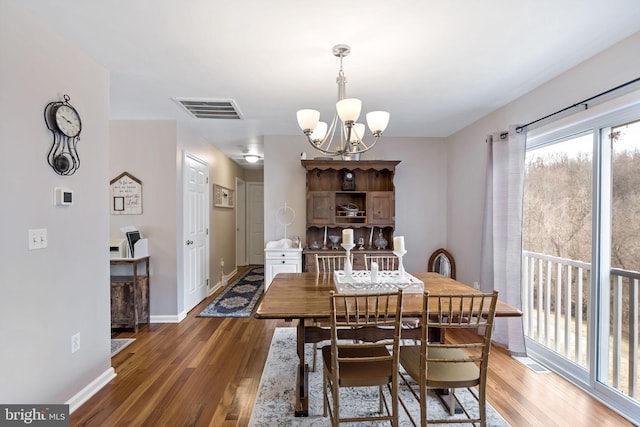 dining room with an inviting chandelier, baseboards, visible vents, and dark wood-style flooring