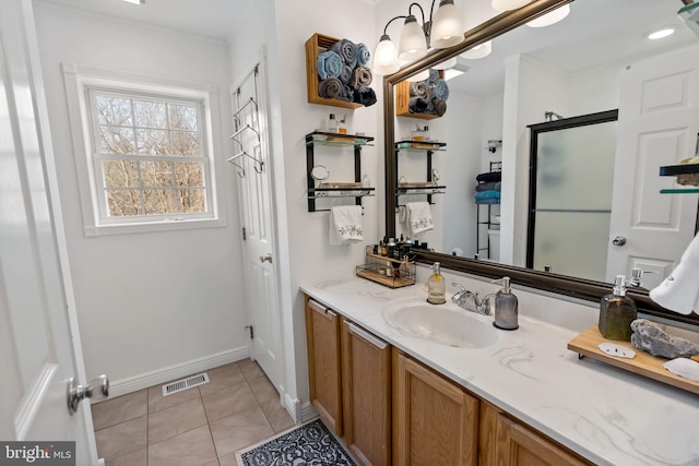 full bathroom featuring vanity, baseboards, visible vents, tile patterned floors, and a shower with door