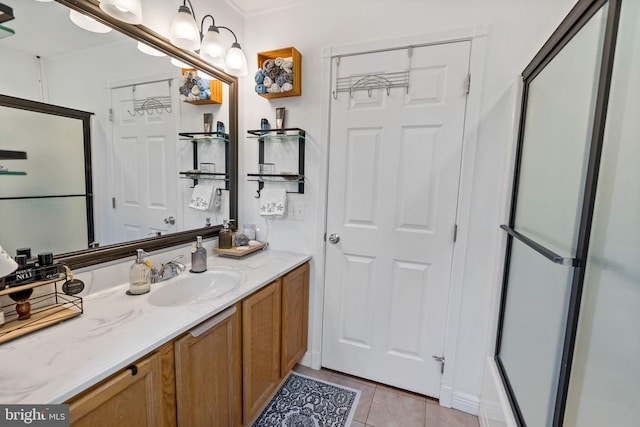 bathroom with a shower with door, tile patterned flooring, and vanity