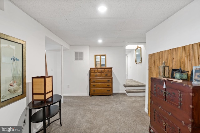 sitting room with baseboards, visible vents, a drop ceiling, stairway, and carpet floors