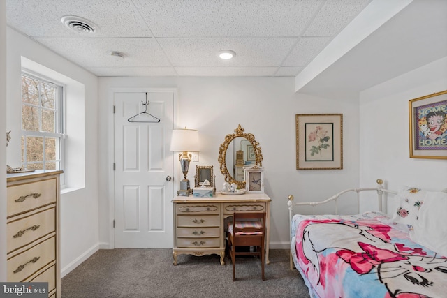 carpeted bedroom with baseboards, visible vents, and a drop ceiling