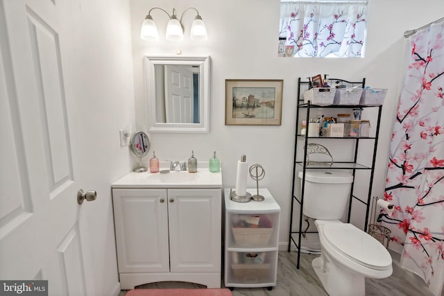 full bath with toilet, curtained shower, and vanity