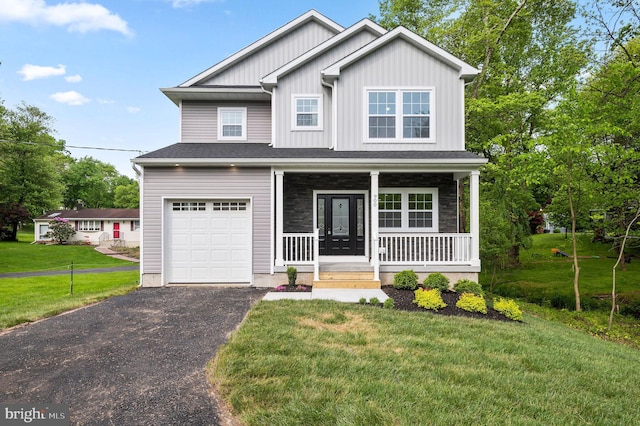 view of front of home with stone siding, aphalt driveway, an attached garage, covered porch, and a front lawn