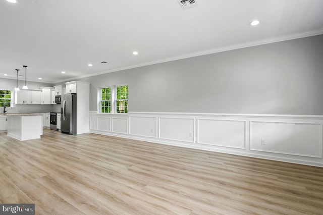 unfurnished living room featuring light wood-style floors, recessed lighting, a healthy amount of sunlight, and visible vents