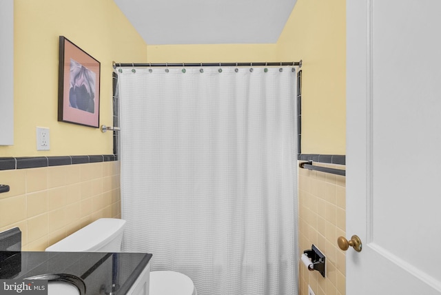 full bathroom featuring a shower with shower curtain, tile walls, toilet, and vanity