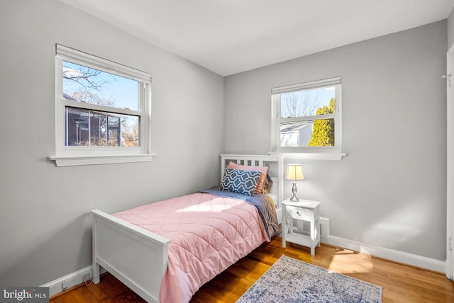 bedroom with baseboards and wood finished floors