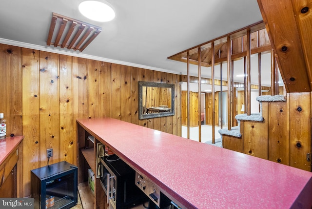 home office featuring ornamental molding and wood walls