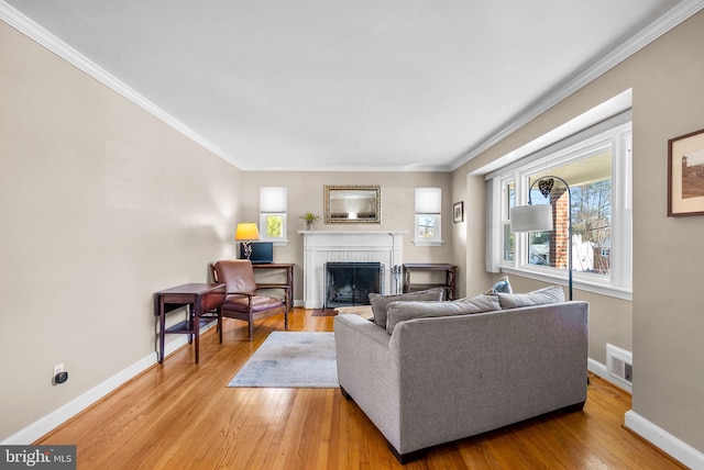 living room featuring light wood-style floors, visible vents, a fireplace, and baseboards