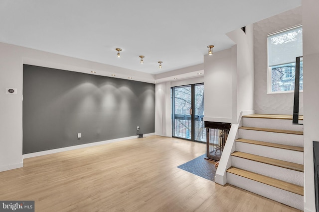 foyer entrance featuring stairs, baseboards, and wood finished floors