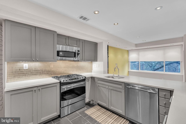 kitchen with appliances with stainless steel finishes, visible vents, and gray cabinetry