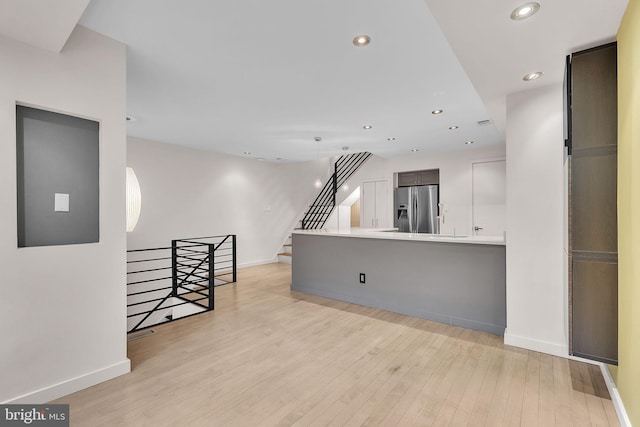 interior space featuring baseboards, recessed lighting, stairs, and light wood-style floors