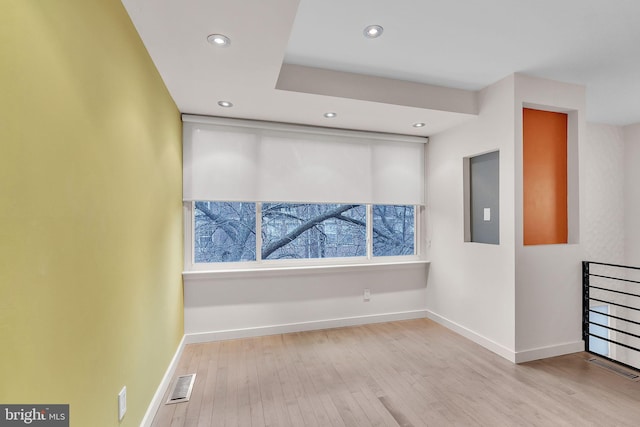 unfurnished room with baseboards, visible vents, wood finished floors, and recessed lighting