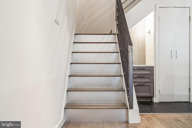 stairs featuring wood finished floors