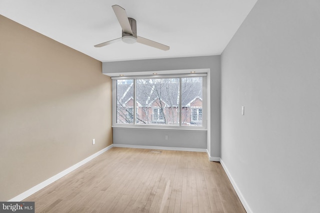 spare room featuring ceiling fan, baseboards, and wood finished floors