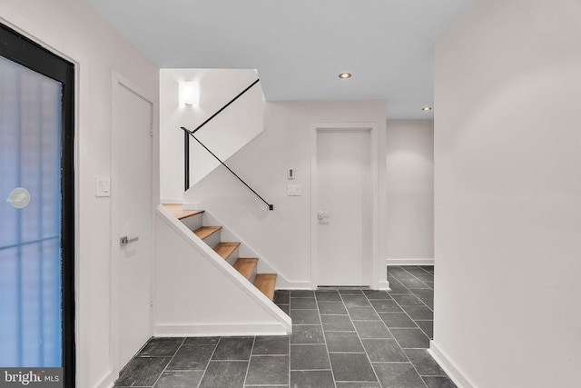 entrance foyer with dark tile patterned flooring, baseboards, recessed lighting, and stairs