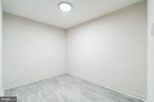 unfurnished room with baseboards