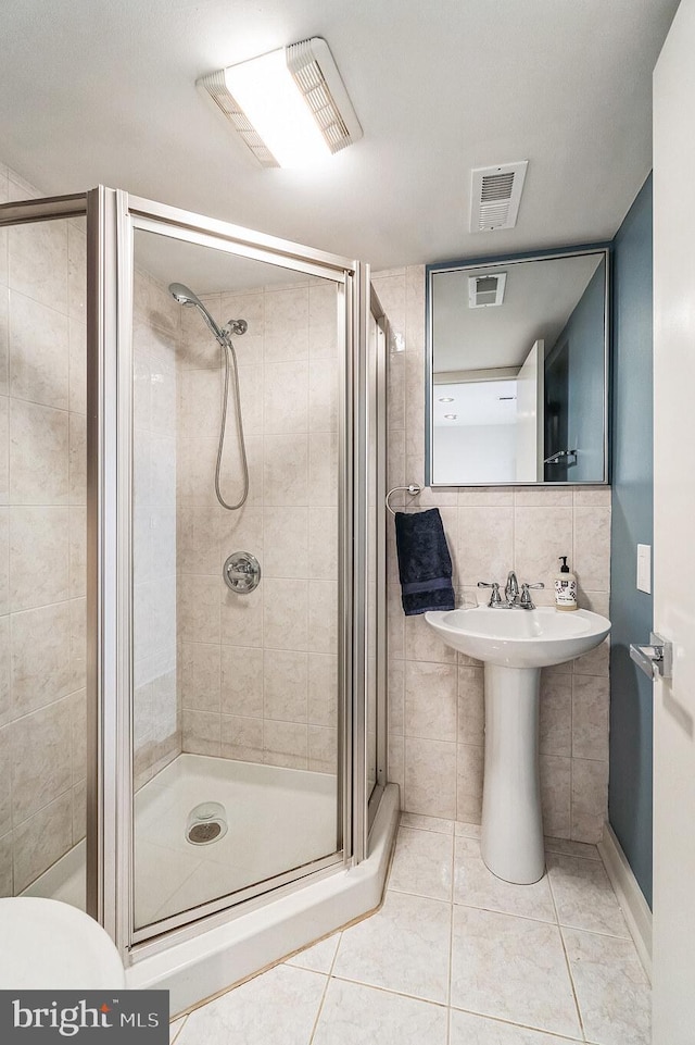 bathroom with a stall shower and visible vents