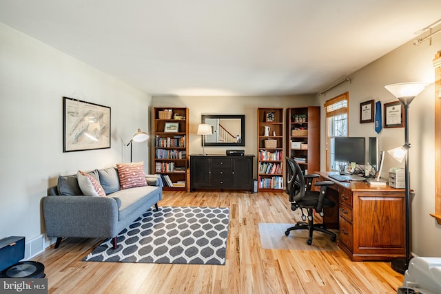 office area with visible vents, baseboards, and light wood-style floors