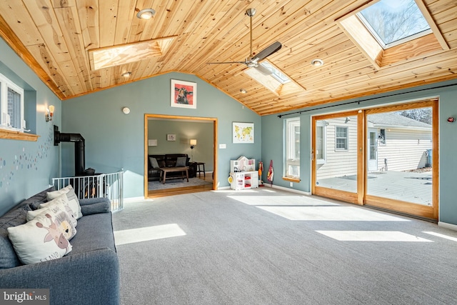 unfurnished living room featuring baseboards, lofted ceiling with skylight, carpet, and wooden ceiling