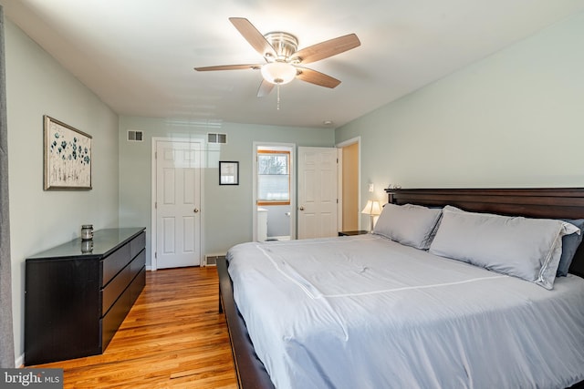 bedroom with a ceiling fan, visible vents, and light wood finished floors