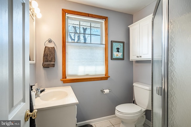 bathroom with tile patterned flooring, baseboards, toilet, a shower with shower door, and vanity