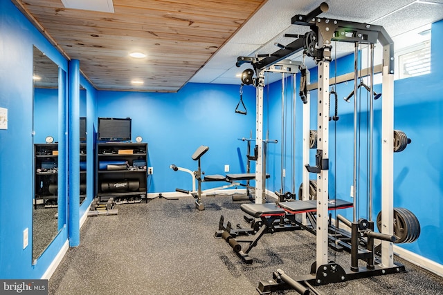 exercise area featuring wooden ceiling and baseboards