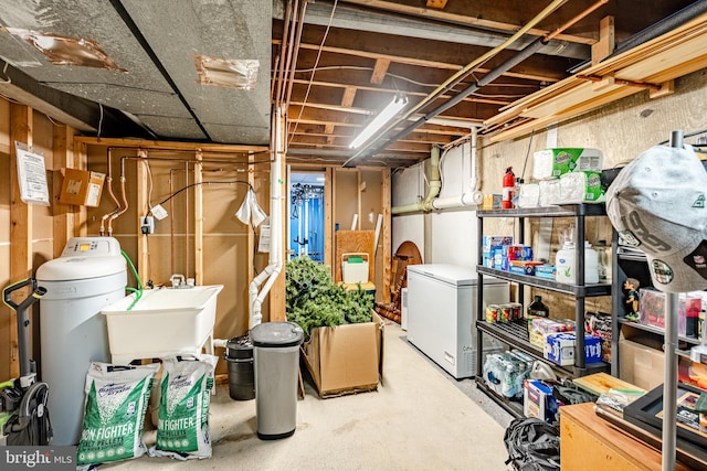 unfinished basement with fridge and a sink