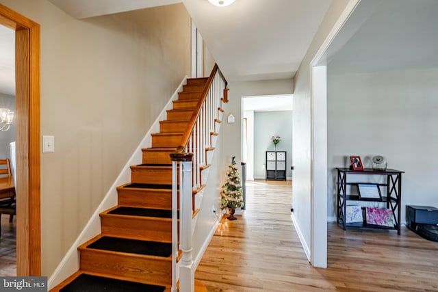 stairway with baseboards and wood finished floors