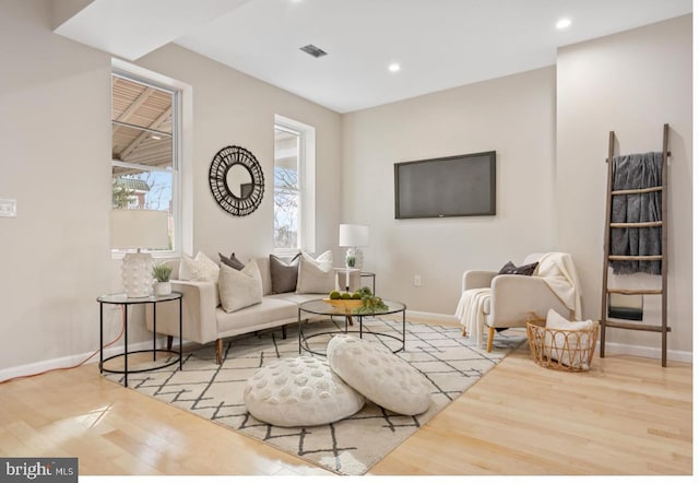 living room with light wood-type flooring, baseboards, and recessed lighting