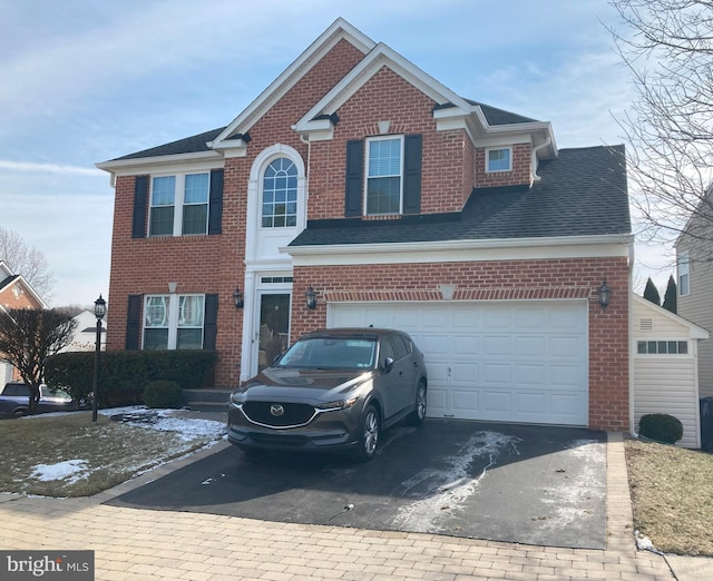 view of front of property with a garage, brick siding, driveway, and roof with shingles