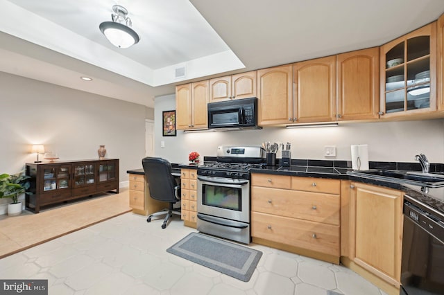 kitchen with dark countertops, visible vents, light brown cabinetry, black appliances, and a sink