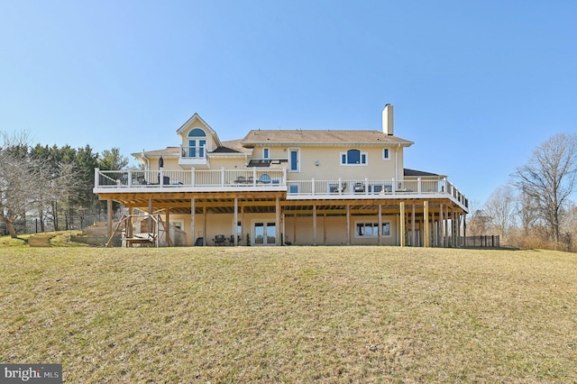 rear view of property with a lawn, a chimney, french doors, and a wooden deck